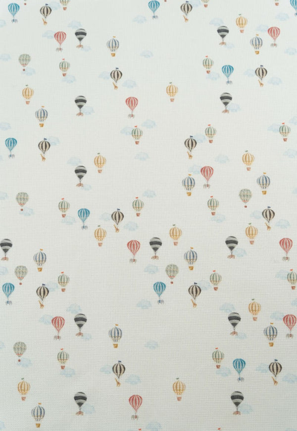 Tejido con estampaod infantil de globos aerostáticos y nubes en tonos suaves y pastel.