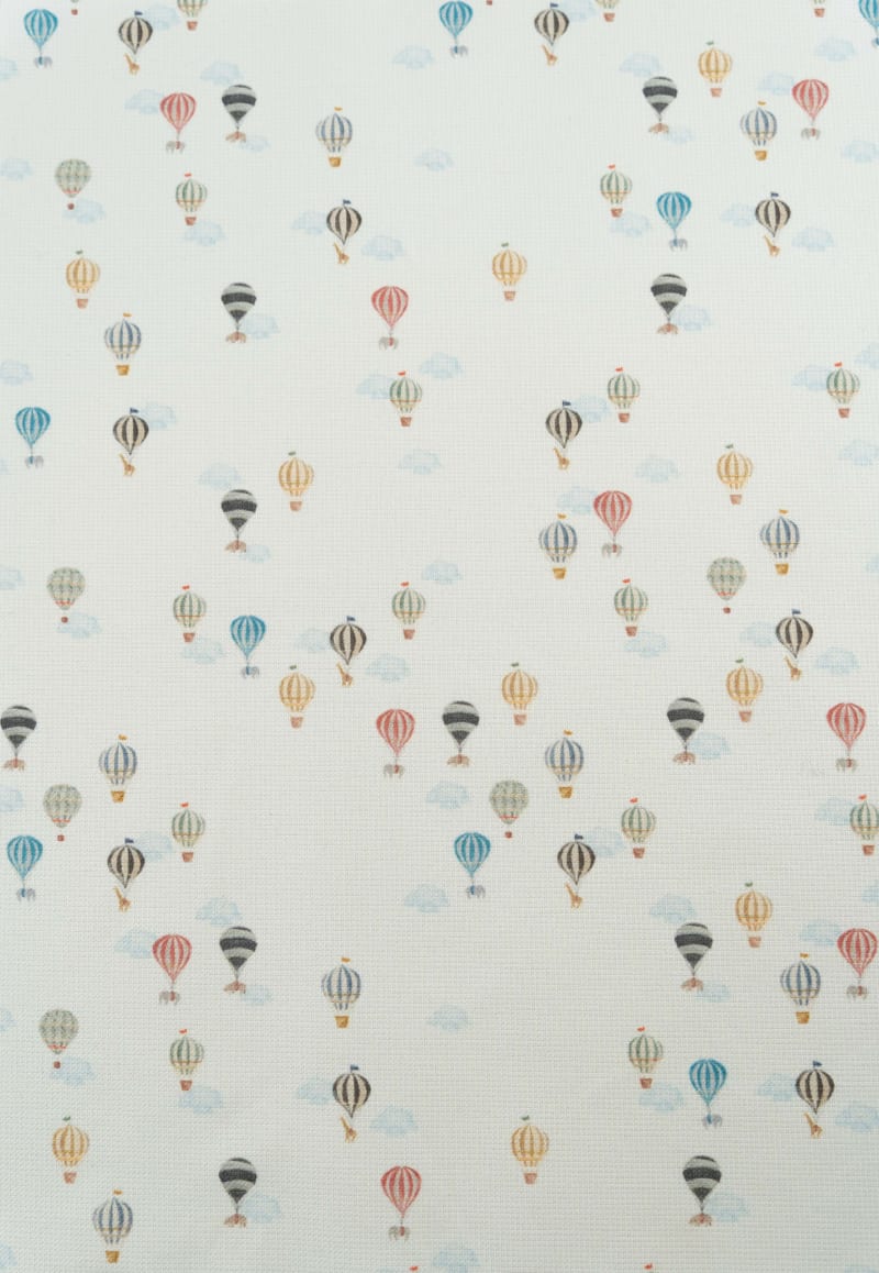 Tejido con estampaod infantil de globos aerostáticos y nubes en tonos suaves y pastel.