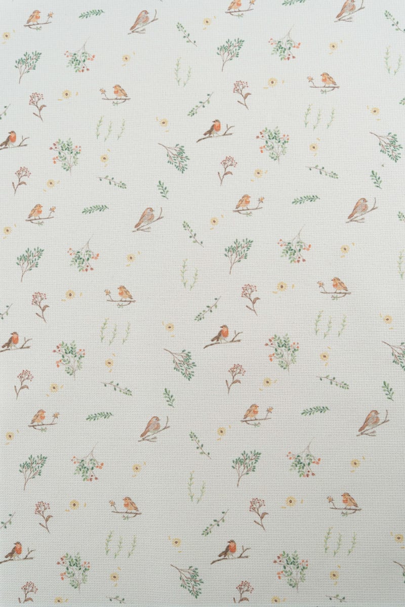 Tejido con estampado infantil de pajaros y flores en tonos suaves y pastel.