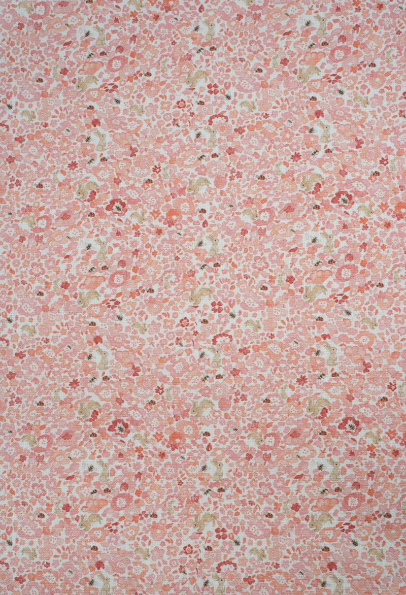 Tejido con estampado infantil de flores en tonos suaves.