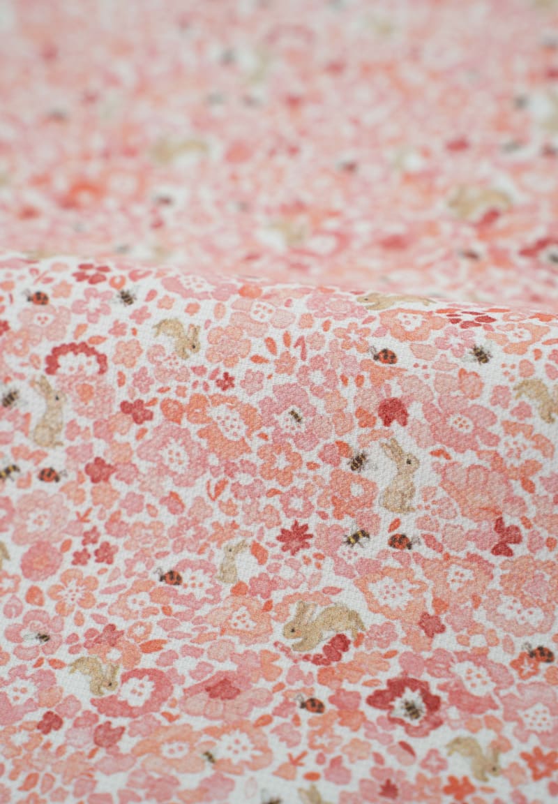 Tejido con estampado infantil de flores en tonos suaves.