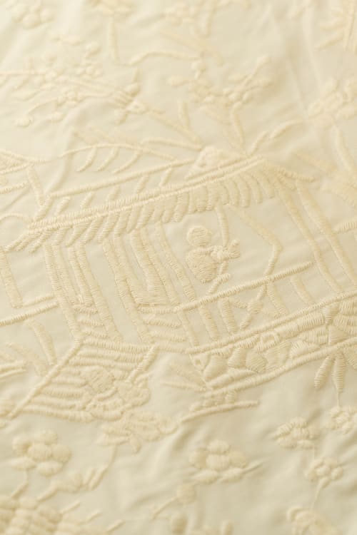 Tela bordada con chinitos color crema