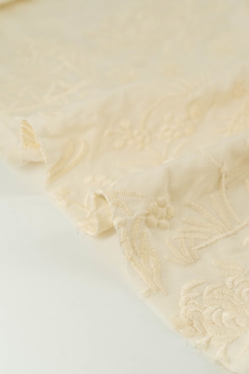 Tela bordada con chinitos color crema