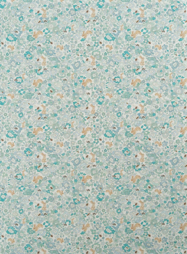 Tejido infantil con estampado de flores y conejos. En tonos azules y patel. 