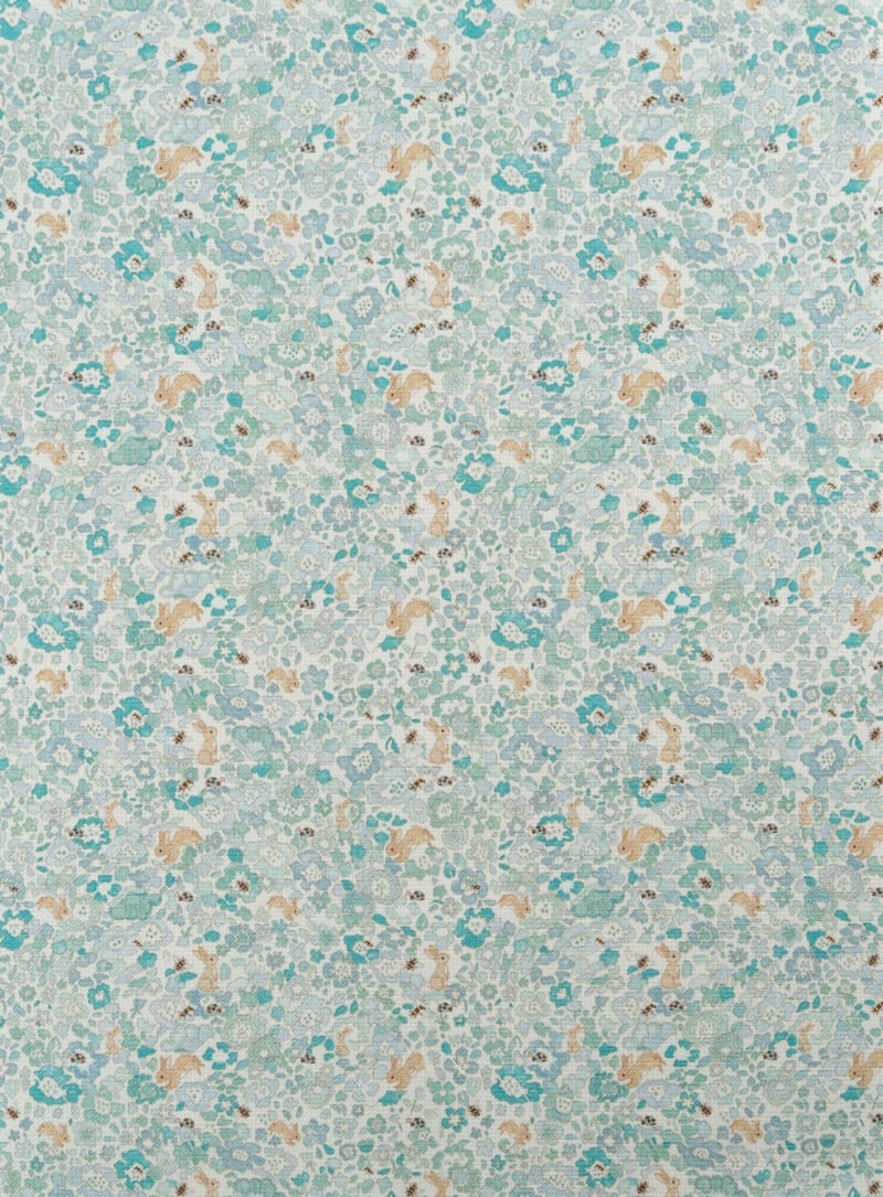 Tejido infantil con estampado de flores y conejos. En tonos azules y patel. 