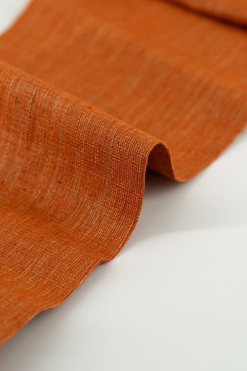 Seda rústica en color naranja albaricoque. Tejido con entramado visible de fibras naturales.
