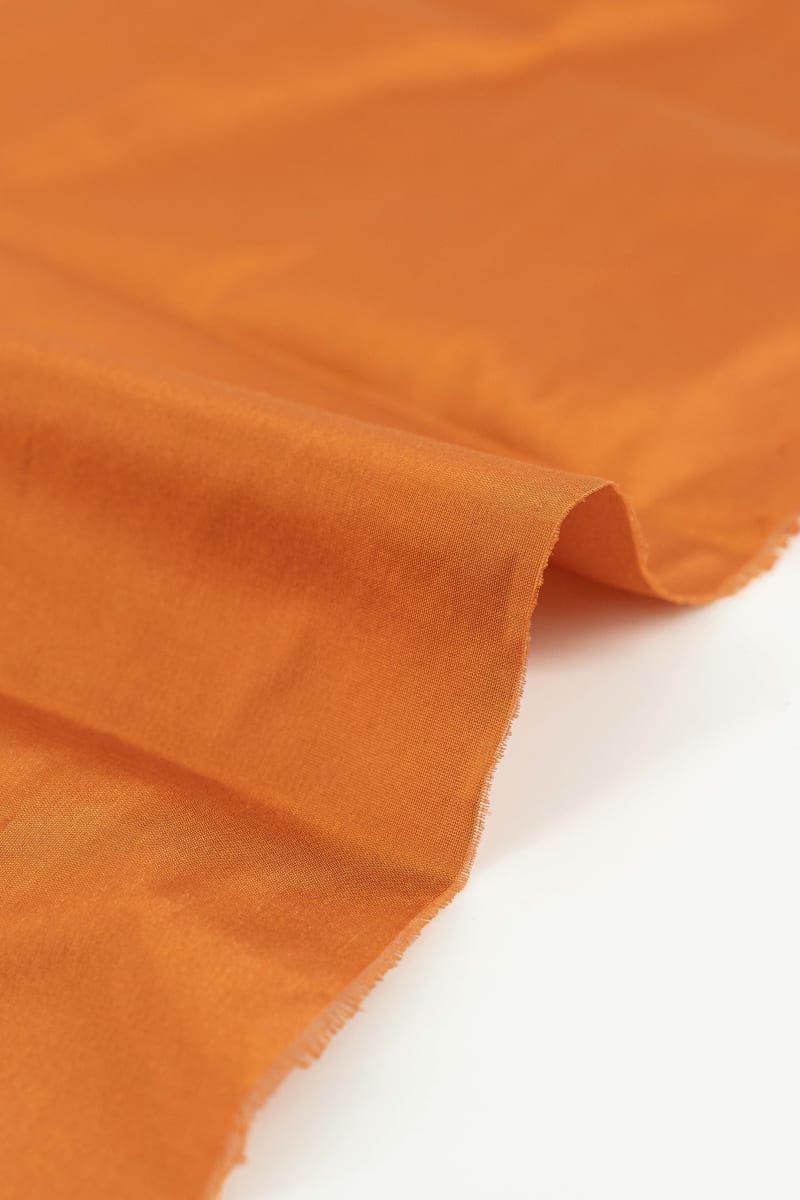 Seda natural en color  naranja albaricoque  con entramado ligeramente visible.