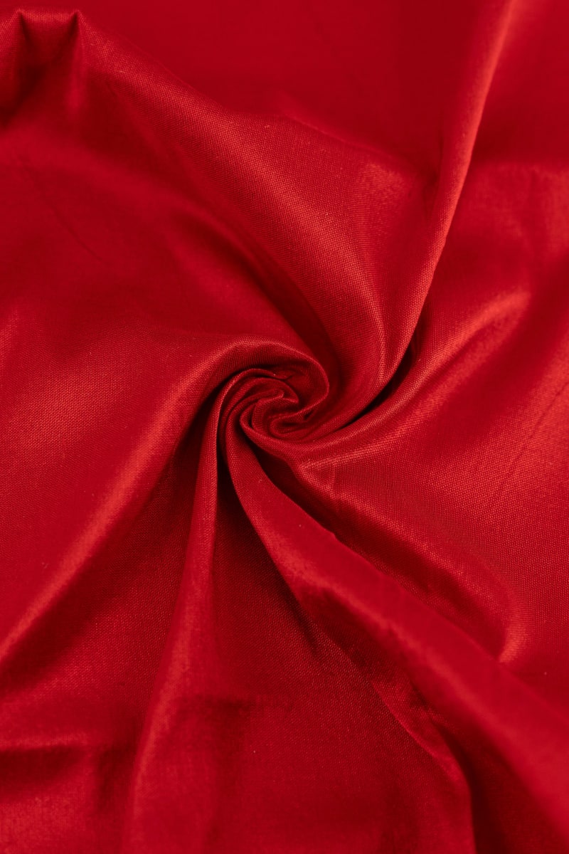 Seda natural en color  rojo teja  con entramado ligeramente visible.