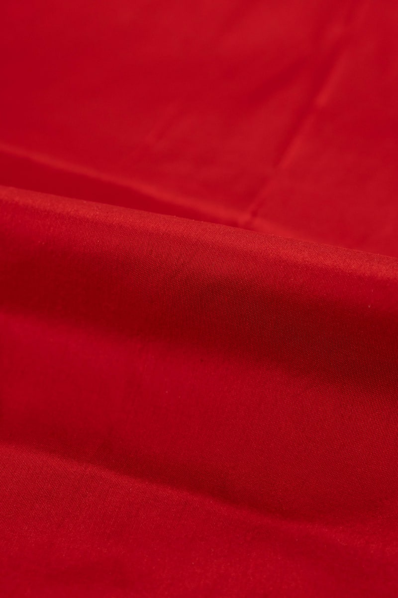 Seda natural en color  rojo teja  con entramado ligeramente visible.