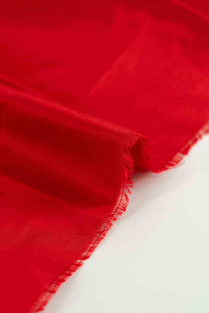 Seda natural en color  rojo teja  con entramado ligeramente visible.