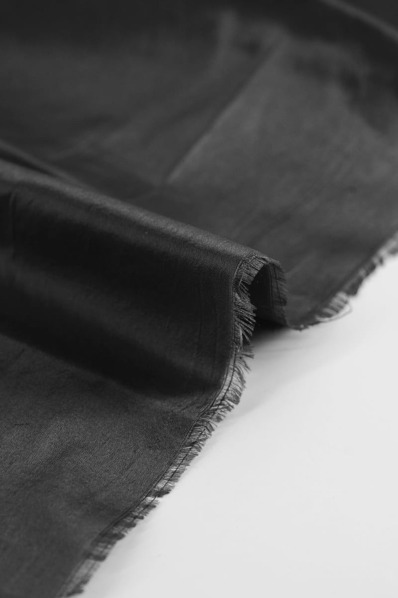 Seda natural en color negro caviar  con entramado ligeramente visible.